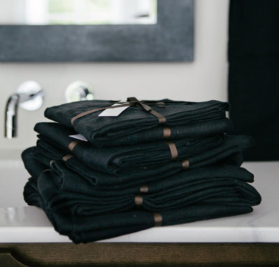 folded stack of 100% linen bathroom linens including bath sheet bath towel hand towel bath mat wash cloths heavyweight Orkney linen fabric black color