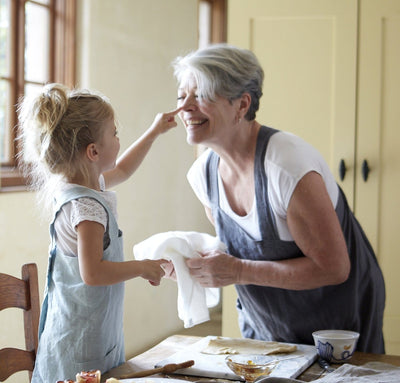 woman with child wearing 100% linen pinafore apron wrap design heavyweight Orkney linen fabric with pockets charcoal color