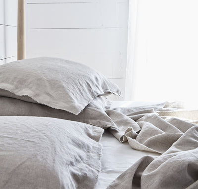 bedroom scene with 100% linen pillow slip covers with raw edge detail natural beige light brown tan color