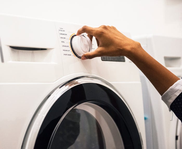 A person operating a washing machine
