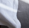 closeup detail of 100% linen pillow slip cover with raw edge detail pure white