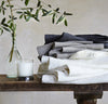 folded stack of 100% linen bath towels sturdy antimicrobial fast drying heavyweight Orkney linen fabric off-white white natural light brown tan charcoal black colors