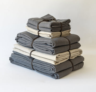folded stack of 100% linen queen bed-in-a-bag set with duvet pillow shams summer cover flat sheets heavyweight Orkney linen fabric charcoal dark grey natural light brown beige tan colors