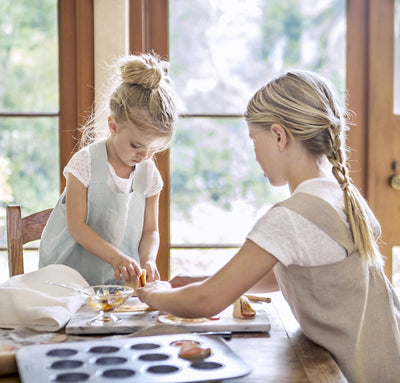 children wearing 100% linen pinafore aprons light blue aqua natural beige tan light brown colors