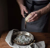 man shredding cheese wearing 100% linen apron heavyweight Orkney linen fabric charcoal dark grey color