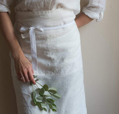 woman wearing 100% linen apron heavyweight Orkney linen fabric off-white white color