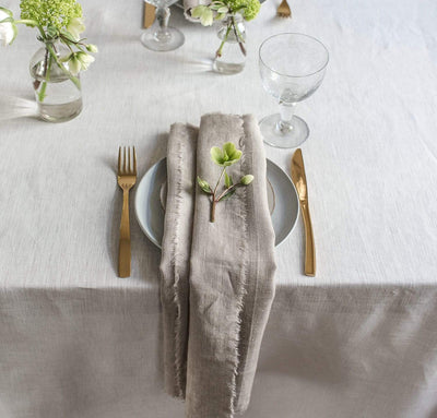 dining table scene with 100% linen napkin smooth texture lightweight linen fabric un-dyed natural beige tan color