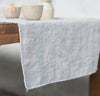 closeup detail of table with 100% linen table runner raw edge detail pure white color
