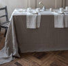 dining table scene with 100% linen tablecloth smooth texture lightweight linen fabric un-dyed natural beige taupe color