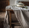 dining table scene with 100% linen tablecloth smooth texture lightweight linen fabric un-dyed natural beige taupe color